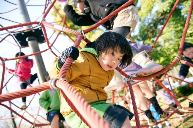 公園の遊具で遊ぶ子供